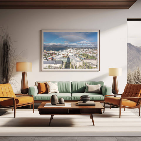 A vivid, full rainbow arching over the colorful red and blue rooftops of Reykjavik, Iceland, under a dramatic Arctic sky.