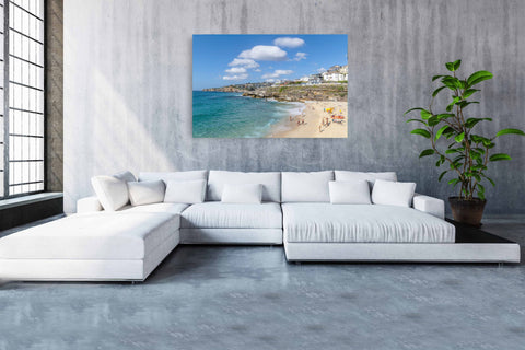Bronte Beach in Sydney, Australia, with massive white clouds over the turquoise ocean and a rocky coastline.