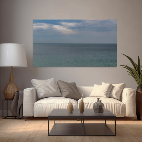 A minimalist horizontal view of the Mediterranean Sea horizon in Cannes, France, with pale blue water and a clear sky.