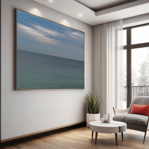 A minimalist horizontal view of the Mediterranean Sea horizon in Cannes, France, with pale blue water and a clear sky.