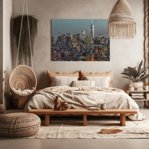 A dusk photograph of the Downtown Manhattan skyline with city lights shining on a clear blue sky.