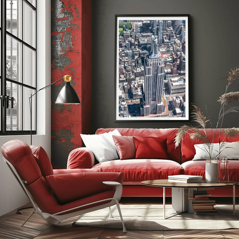 A high-altitude helicopter photograph looking directly down at the spire and setbacks of the Empire State Building.