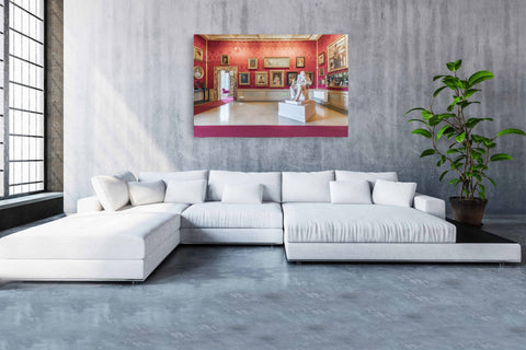Interior photography of a red-walled gallery room in the Accademia Museum, Florence, featuring Renaissance paintings and classical busts.