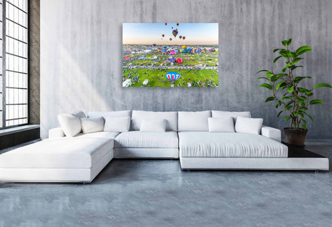 A wide-angle sunrise shot of the Albuquerque International Balloon Fiesta, featuring hundreds of colorful hot air balloons lifting off into a golden New Mexico sky.