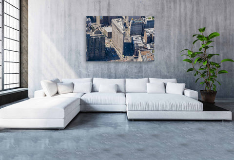 An aerial helicopter photograph looking down at the triangular roof of the Flatiron Building at the intersection of 5th Ave and Broadway.