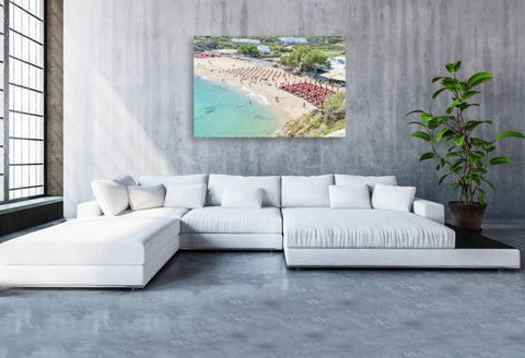 High-angle tilt shift view of Super Paradise Beach in Mykonos, featuring turquoise water and tiny-looking blue umbrellas.